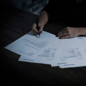 Documents spread across a table, person reviewing.